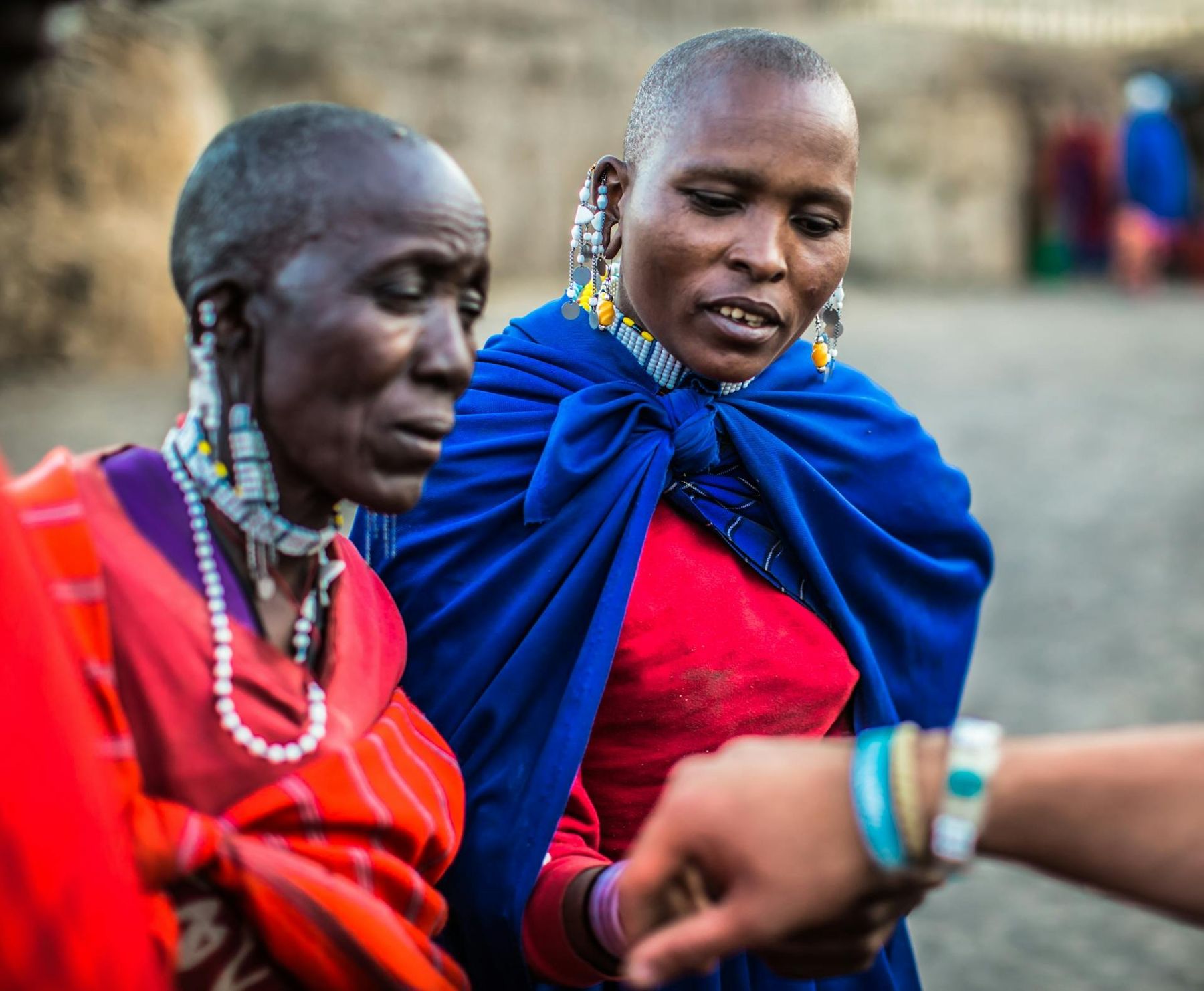 Two Maasai women in beaded jewellery and bright shawls